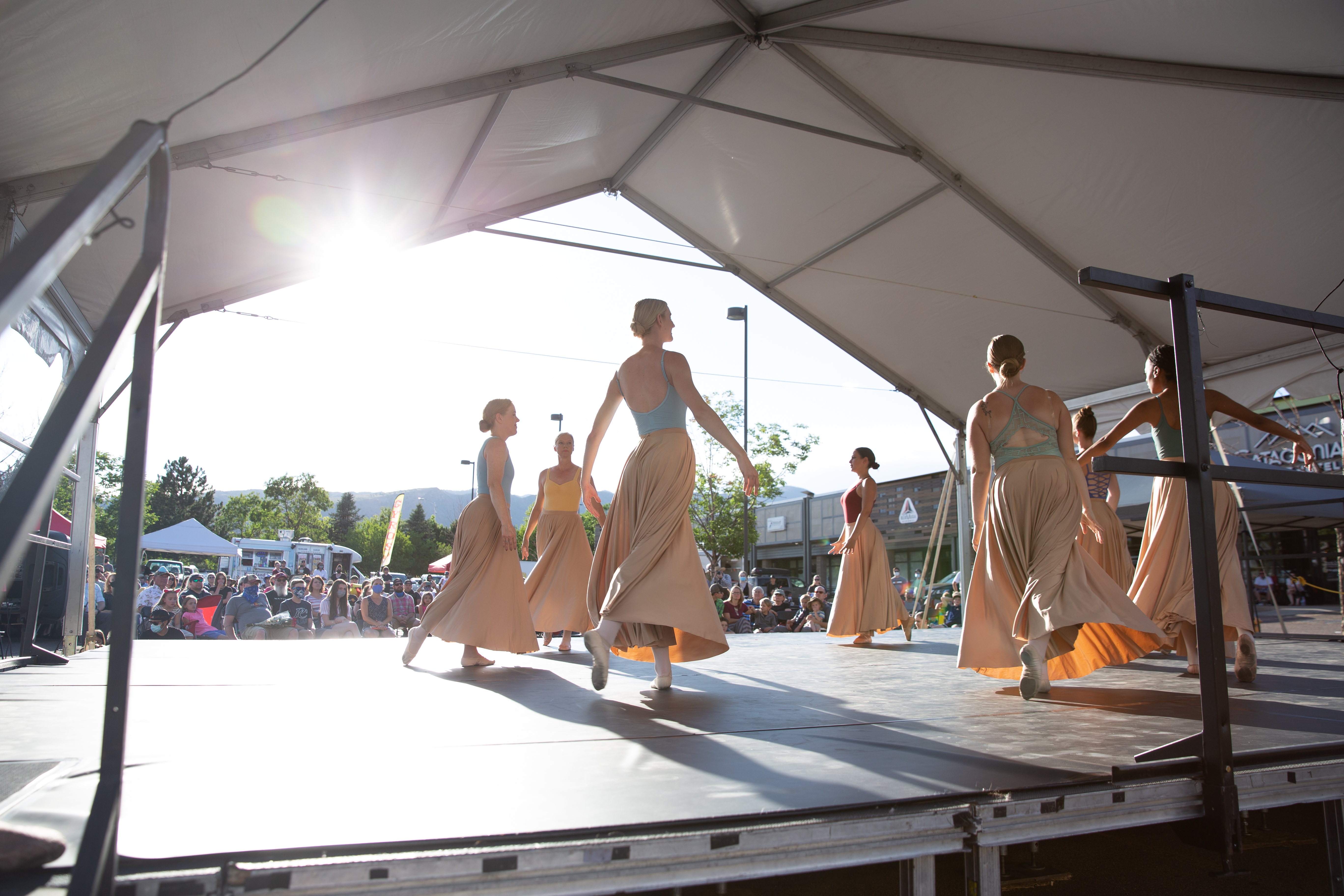 adult dancers in long skirts on an outdoor stage