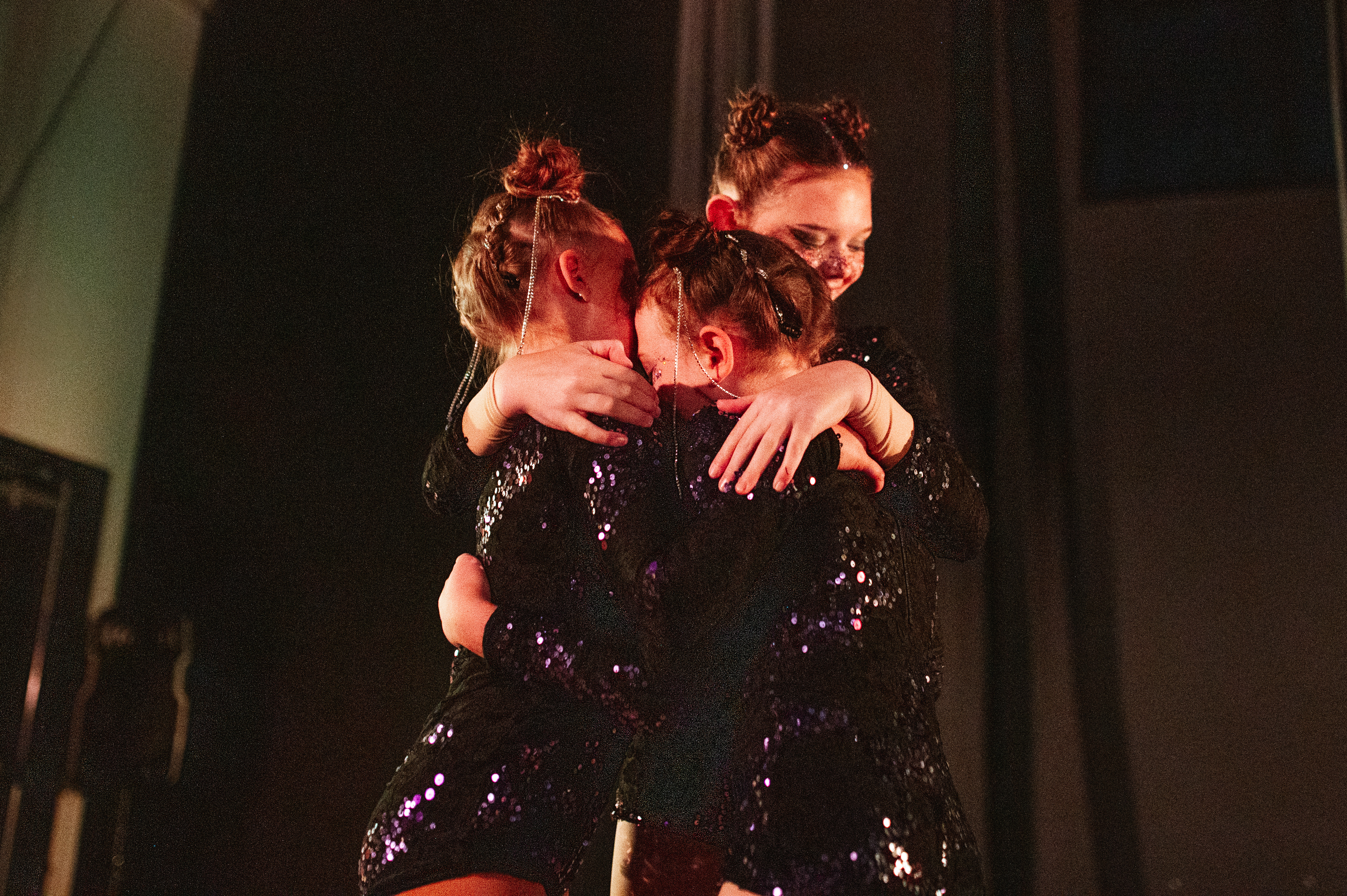 youth students hugging each other onstage